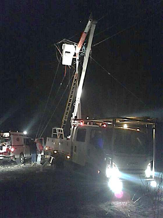 Brigada de emergencia trabajando de noche con camión pluma